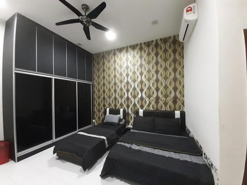 a bedroom with two beds and a ceiling fan at Selesa Indah Guest House Melaka - Near City Centre in Melaka