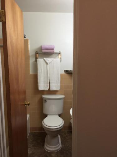 a bathroom with a white toilet and towels at Lazy U Motel in Rapid City
