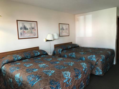 a hotel room with two beds and a lamp at Lazy U Motel in Rapid City