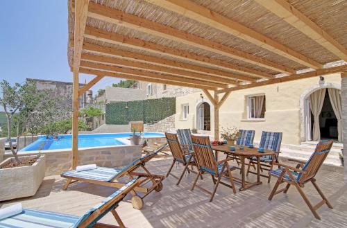 eine Terrasse mit Stühlen, einem Tisch und einem Pool in der Unterkunft Villa Sea star in Babino Polje