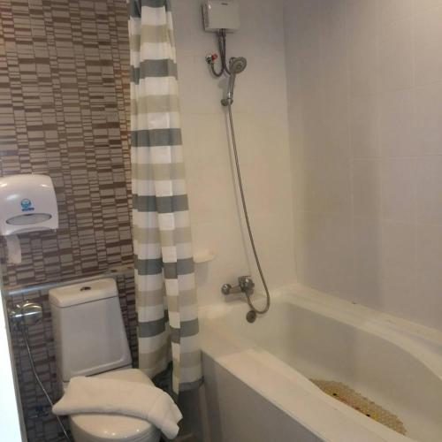 a bathroom with a toilet and a tub and a shower at Kwan Ruen Park in Nakhon Ratchasima