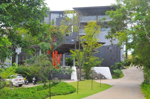 a building with a staircase in a park with trees at The Houben - Adult Only in Ko Lanta