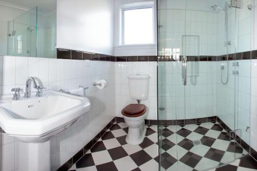 a bathroom with a sink and a toilet and a shower at McDougall Cottage in Wanaka