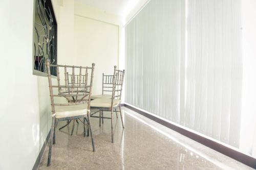 two chairs and a table in a room at Fj Manila Hotel in Daraga