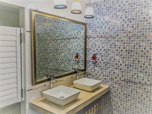 a bathroom with two sinks and a mirror at Bangkok Saran Poshtel in Bangkok