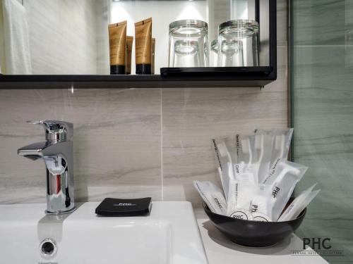a bathroom sink with a bowl of tooth brushes at Magazine Vista Hotel by PHC in George Town
