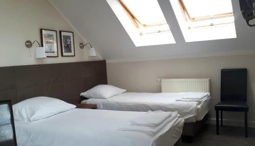 two beds in a room with skylights at Zajazd Podzamcze in Fałków