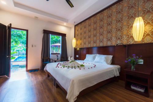 Un dormitorio con una cama grande con un arreglo floral. en Phu Quoc Villa, en Phu Quoc