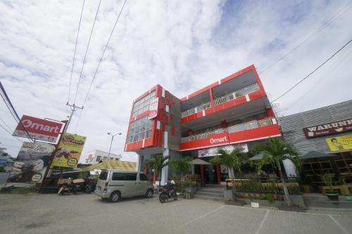 a red building with a van parked in front of it at RedDoorz Plus Syariah @ Pentadio Gorontalo in Gorontalo
