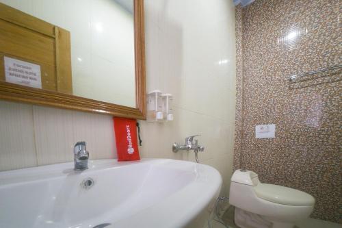 a bathroom with a sink and a toilet and a mirror at RedDoorz Plus Syariah @ Pentadio Gorontalo in Gorontalo