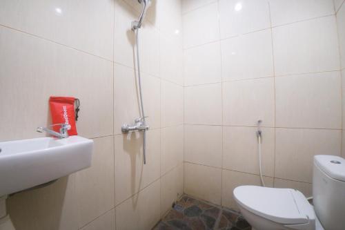 a bathroom with a toilet and a sink at RedDoorz near TVRI Gorontalo in Telaga