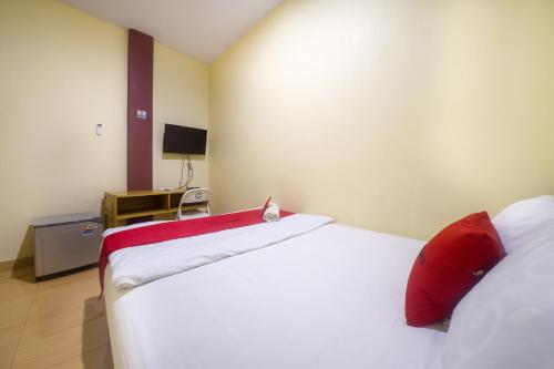 a bedroom with two beds with red pillows at RedDoorz near TVRI Gorontalo in Telaga