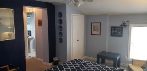 a bedroom with blue walls and a bed and a table at Harrington House Picton in Picton