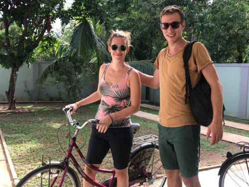 ein Mann und eine Frau stehen neben einem Fahrrad in der Unterkunft Kingdom Gate Hotel in Anuradhapura