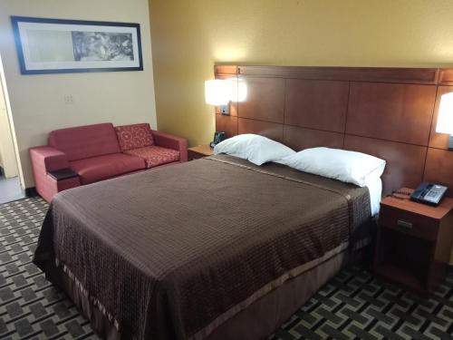 Budget Inn Of Orlando في أورلاندو: غرفه فندقيه بسرير وكرسي