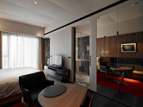 a hotel room with a bed and a dining room at Hotel Proverbs Taipei in Taipei