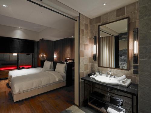 a hotel room with a large bed and a large mirror at Hotel Proverbs Taipei in Taipei