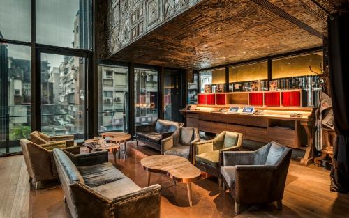 a lobby with chairs and tables and a bar at Hotel Proverbs Taipei in Taipei