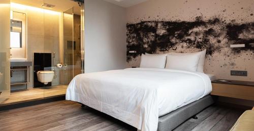 a bedroom with a large white bed and a shower at Brio Hotel in Kaohsiung