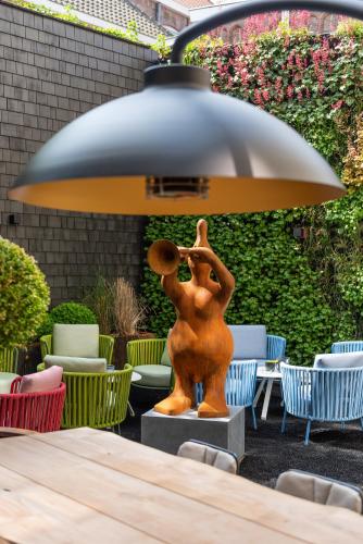 a statue of a man playing a violin under a lamp at Boutique Hotel Sablon by CW Hotel Collection in Bruges