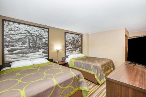 a hotel room with two beds and a flat screen tv at Super 8 by Wyndham Chattanooga Lookout Mountain TN in Chattanooga