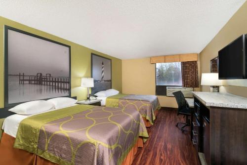 een hotelkamer met 2 bedden en een flatscreen-tv bij Super 8 by Wyndham Raleigh North East in Raleigh