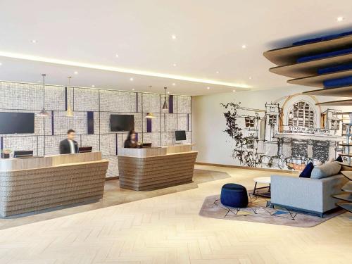 a lobby of a hotel with a reception desk at Novotel Jakarta Mangga Dua Square in Jakarta