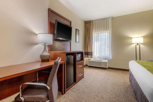 a hotel room with a desk with a television and a bed at Comfort Inn Lenoir City-Knoxville in Lenoir City