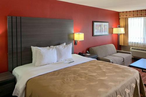 una habitación de hotel con una cama grande y una silla en Quality Inn Marshall, en Marshall