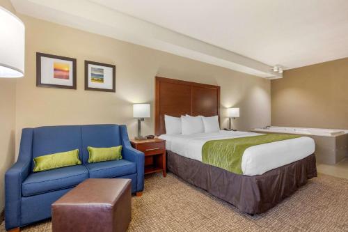 a hotel room with a bed and a blue chair at Comfort Inn Lenoir City-Knoxville in Lenoir City