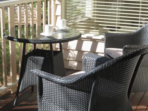 a patio table and chairs on a porch at Delderfield Villas Adults Retreat in Marysville