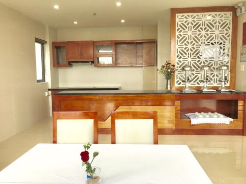 a kitchen with a table and chairs and a counter at Windy Hotel Quang Binh in Dong Hoi