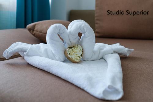 dois cisnes feitos de toalhas numa cama em Saona Residence Mamaia Nord em Mamaia Nord – Năvodari