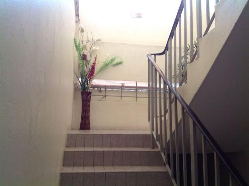 a vase of flowers sitting on a stair case at Hotel Morning Glory in Kudat