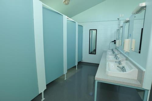 a bathroom with two sinks and two mirrors at Picton's Waikawa Bay Holiday Park in Picton