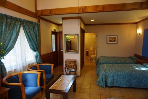 una camera d'albergo con due letti e un tavolo con sedie di Private Hotel Rei a Fujikawaguchiko