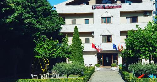 a large white building with trees in front of it at Hotel Ambasador Garden in Lezhë