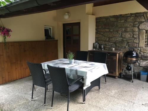 a dining table with chairs and a stone wall at Chalupa Herman in Rudník