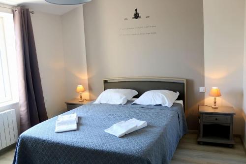 ein Schlafzimmer mit einem Bett, auf dem zwei Handtücher liegen in der Unterkunft L'EDEN DE LA HAUTE FORET in Mervent