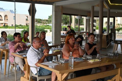 a group of people sitting at tables in a restaurant at Kavos Hotel & Suites in Stavros