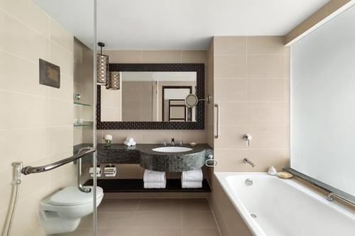 a bathroom with a sink and a tub and a toilet at Shangri-La Tanjung Aru, Kota Kinabalu in Kota Kinabalu