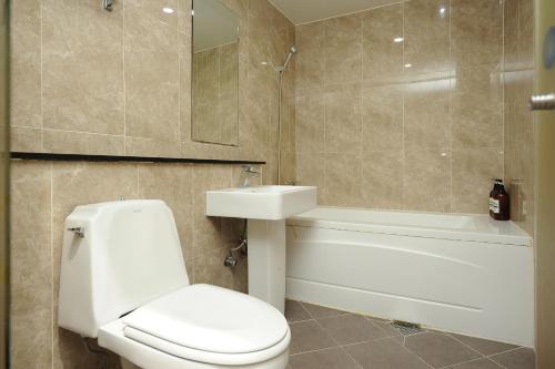 a bathroom with a toilet and a sink and a tub at Hotel MIDO Myeongdong in Seoul