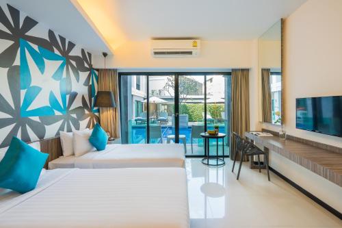 Una habitación de hotel con dos camas y un televisor. en Hotel J Residence Pattaya, en Pattaya central