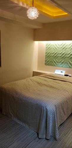 a bedroom with a bed and a painting on the wall at HOTEL KAZAN (Adult Only) in Iwaki