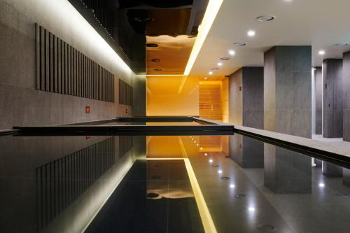 a swimming pool in a building with a ceiling at Hotel Hyundai by Lahan Ulsan in Ulsan