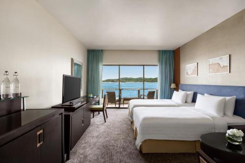 a hotel room with two beds and a television at Shangri-La Tanjung Aru, Kota Kinabalu in Kota Kinabalu