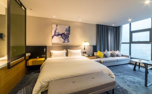 a hotel room with a large bed and a couch at 成都V hotel精品酒店 in Chengdu