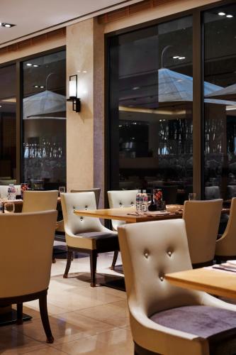 a restaurant with tables and chairs and windows at Hotel Hyundai by Lahan Ulsan in Ulsan