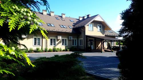 una grande casa gialla con tetto di gamberetti di Zajazd Podzamcze a Fałków
