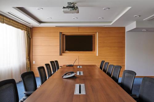 a conference room with a table and a television at Hotel Hyundai by Lahan Ulsan in Ulsan